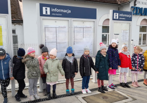 Grupa dzieci stoi na peronie i czeka na przyjazd pociągu.