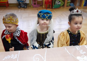 Dzieci siedzą przy stole.