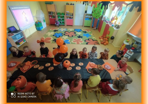 Zdjęcie grupowe przy udekorowanym tematycznie stole.
