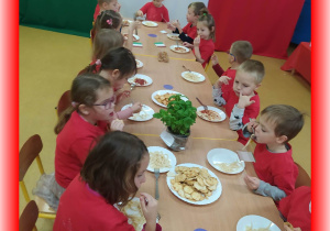 Dzieci jedzą samodzielnie wykonane spaghetti.