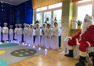 Dzieci przebrane za aniołki z Mikołajem