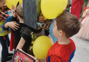 Dwóch chłopców tańczy z balonami.