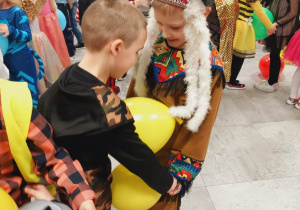 Dwóch chłopców wspólni trzyma balon.