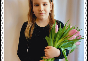 Dziewczynka trzyma różowe tulipany.