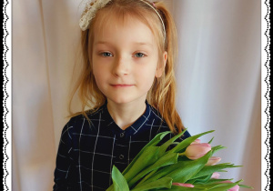 Dziewczynka trzyma różowe tulipany.