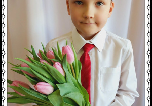 Chłopiec trzyma różowe tulipany.