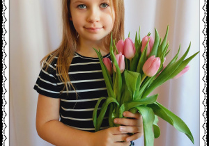 Dziewczynka trzyma różowe tulipany.