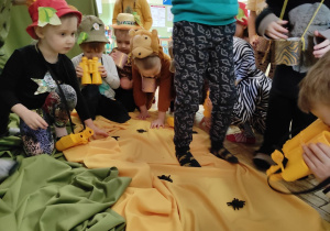 Dzieci obserwują pająki, które spotkały na swojej drodze