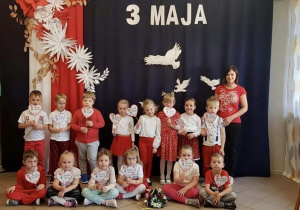 Dzieci z grupy 3, na tle dekoracji z okazji obchodów 3 Maja