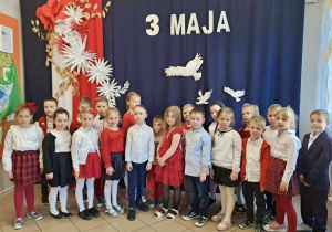 Dzieci z grupy 4, na tle dekoracji z okazji obchodów 3 Maja