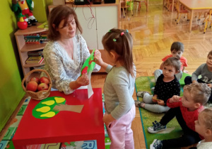 Hania zrywa jabluszko z drzewa