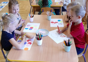 Dzieci przy stoliczku w czasie pracy plastycznej.