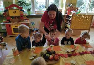 Pani pokazuje dzieciom jak wyglądają owoce w środku