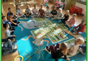 Dzieci z grupy Liski siedzą na dywanie i uczą się układać sudoku z kartami emocji