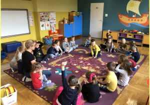 Dzieci z grupy Jeżyki siedzą na dywanie i uczą się układać sudoku z kartami emocji