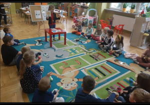 Kasia z Lisków pokazuje kartę emocji i dzieci grają na instrumencie zgodnie z ustalonym kodem