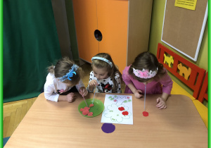 Dzieci z Jeżyków siedzą przy stolikach i biorą udział w zabawach logopedycznych.