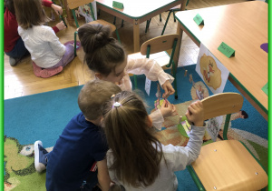 Dzieci z Lisków siedzą przy stolikach i biorą udział w zabawach logopedycznych.