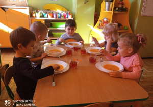 Dzieci jedzą zupę dyniową