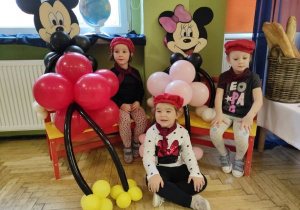 Hania, Maja i Wiktoria siedzą obok zrobionych z balonów postaci Myszki Miki i Minnie.