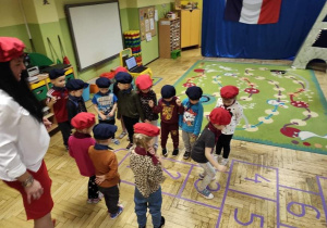 Dzieci poznają zasady francuskiej gry Marelle.
