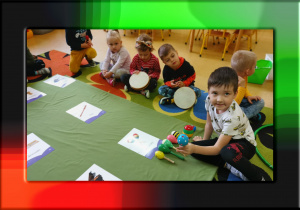 Na zdjęciu grupa dzieci, przed nimi leżą instrumenty