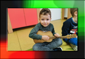 Chłopiec gra na gitarze.