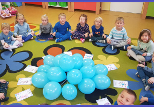 Biedronki w niebieskich strojach i z niebieskimi balonami poznają prawa dziecka