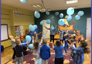 Jeżyki bawią się niebieskimi balonami
