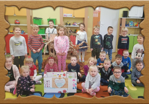 Na zdjęciu grupa dzieci , przed nimi kolororwe pudełko - nasz kącik makulatury.