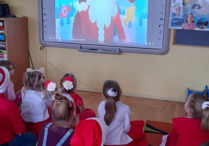 Dzieci oglądają film edukacyjny o św. Mikołaju.