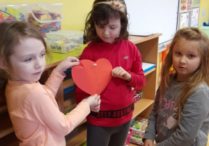 Dziewczynki trzymają czerwone serce.