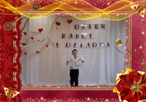 Chłopiec trzyma w rączkach kartki z kalendarza, w tle dekoracja okolicznościowa