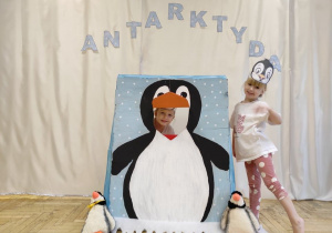 Hania i Amelka przy fotobutce w kształcie pingwina.