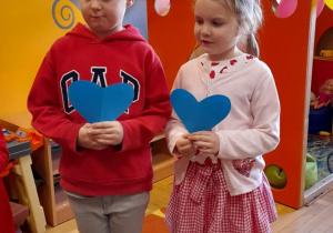 Dzieci trzymają niebieskie serca.