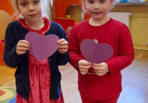 Dziewczynki trzymają fioletowe serca.