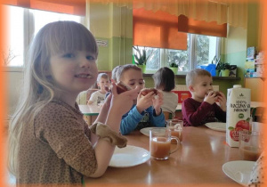 Dzieci jedzą pyszne pączki.