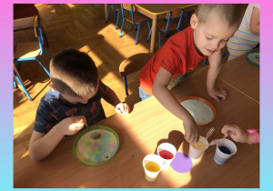 Dzieci malują barwnikami i olejem na mleku