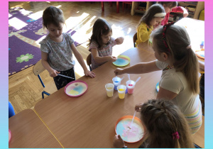 Dzieci malują barwnikami i olejem na mleku