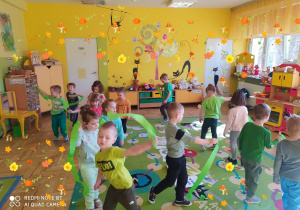 Dzieci tańczą z zielonymi wstążkami.