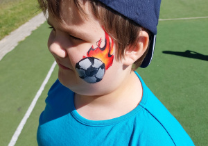 Chłopiec z namalowaną na twarzy piłką