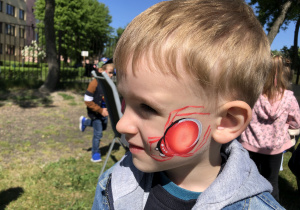 Chłopiec z namalowanym na twarzy pająkiem