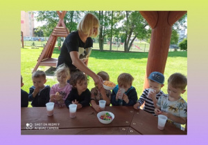 Dzieci jedzą poczęstunek w altance