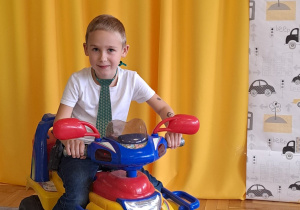 Chłopiec siedzi na motorku.