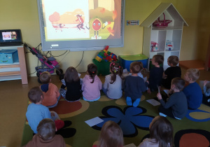 Dzieci oglądają film edukacyjny o jesieni.