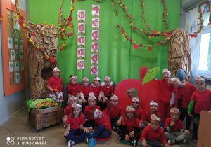 Dzieci na tle dekoracji związanej z dniem jabłka.