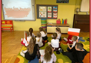 Dzieci oglądają film o historii niepodległości Polski