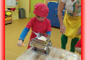 Dzieci robią makaron maszynką do makaronu.