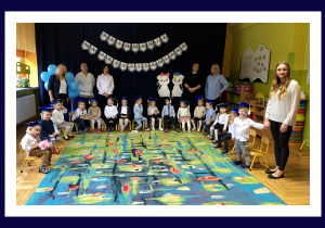 Zdjęcie grupowe na tle dekoracji z okazji pasowania na przedszkolaka.