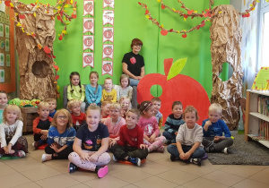 Na zdjęciu grupa dzieci i Pani. W tle dekoracja związana z jabłkami.